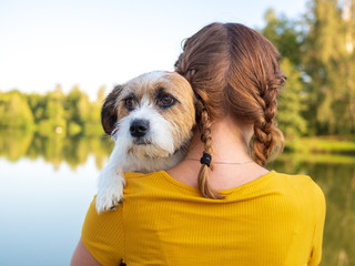 Hund blickt über die Schulter einer jungen Frau, Tierliebe, Herbst, Angst