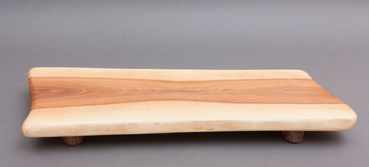 Ecological handmade wooden cutting board on grey background