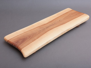 Ecological handmade wooden cutting board on grey background