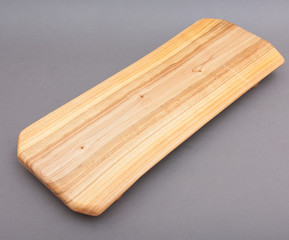 Ecological handmade wooden cutting board on grey background