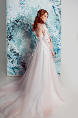 Beautiful and romantic bride in wedding dress with long sleeves. Young redheaded woman in wedding...
