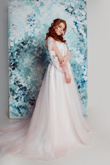 Romantic bride in wedding dress with long sleeves. Young redheaded woman in wedding dress