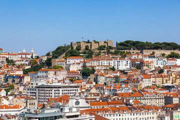 Fototapeta na wymiar Lisbon, Portugal. View of the Castelo de Sao Jorge Castle aka Saint or St. George Castle, the Baixa, Alfama and Mouraria Districts. Typical Portuguese orange rooftops.