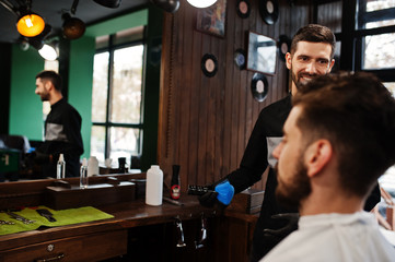 Handsome bearded man at the barbershop, barber at work.
