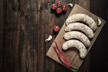 Raw chicken sausages on cutting board