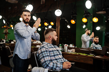 Handsome bearded man at the barbershop, barber at work.