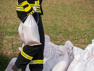 Sandsäcke Hochwasserschutz Feuerwehrmann