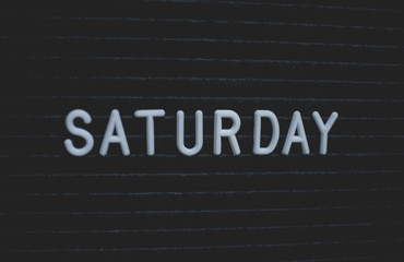 Word saturday written on the letter board. White letters on the black background. Business concept