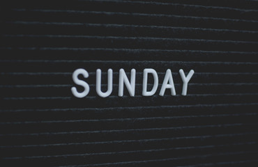 Word sunday written on the letter board. White letters on the black background. Business concept