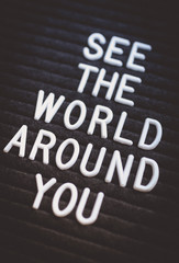 Fototapeta premium Phrase see the world around you written on the letter board. White letters on the black background. Business concept