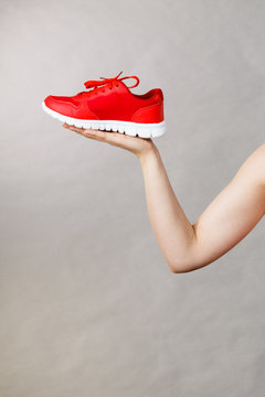 Woman presenting sportswear trainers shoes