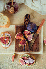 Autumn dessert: bruschetta with ripe figs, soft cheese and honey on a light background.