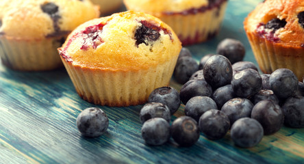 muffin with blueberries on a wooden table. fresh berries and sweet pastries on the board.