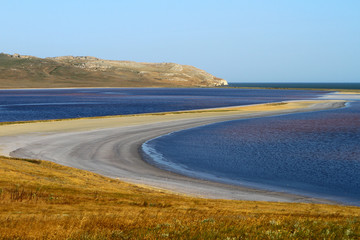 Natural landscape photo of pretty Kayashskoe lake in Crimea, at the Black sea shore with naturally pink salty water.