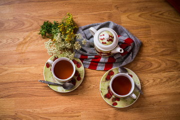 Tea ceremony, filled tea in service with wildflowers on the wood texture