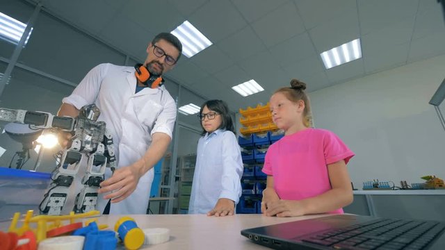 Demonstration process of a toy robot to the children carried out by a male professional