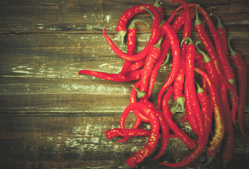 Naklejka premium The composition of chili red hot peppers on wooden table
