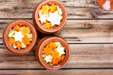 Traditional rustic home vegetable  ragout in three clay pots on old vintage wooden table.