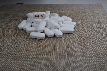 white oval tablet with the inscription "pain"