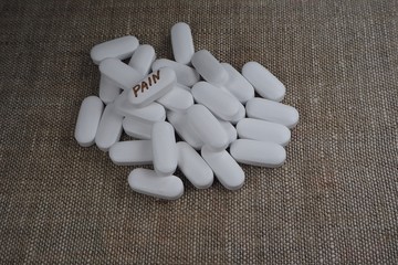 white oval tablet with the inscription "pain"