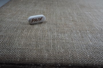 white oval tablet with the inscription "pain"