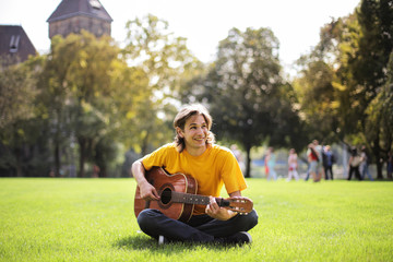 Young man in yellow t-shirt with a guitar.