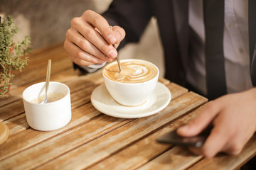 Man's hand with a coffee cup.