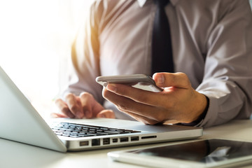 Digital marketing media in virtual screen.businesswoman hand working with mobile phone and modern compute  at office in morning light 