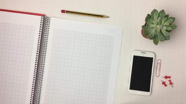 Escena de mesa de oficina con libreta pasando paginas.
