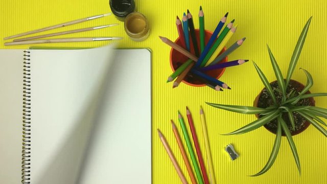 Escena de mesa de dibujo con libreta pasando paginas.