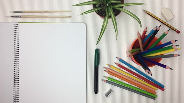 Escena de mesa de dibujo con libreta pasando paginas.