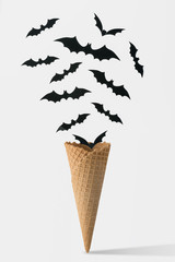 Ice cream cone with bats. Halloween minimal concept.