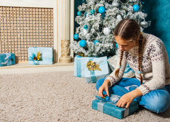 Naklejka premium teenager girl hold presents gift box on Christmas tree background