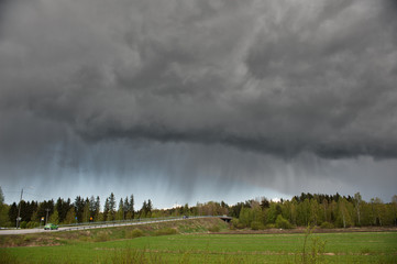 Stormy rain clouds over rural landscape in Finland.