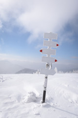 Metal pointer with arrows in winter mountains. Travel concept. Landscape photography