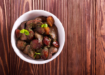 Chicken liver with plums in a bowl