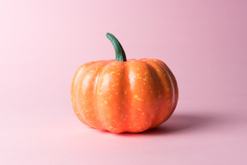 Halloween pumpkin on pastel pink background. Halloween minimal concept.
