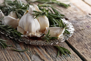 Rosemary and garlic on a wooden table.