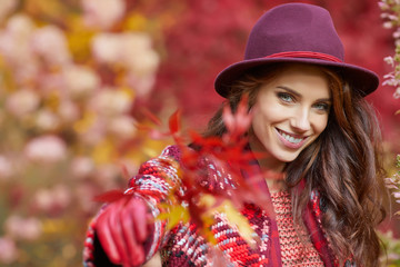 Beautiful elegant woman standing in a park in autumn