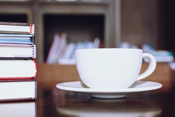 cup coffee on table in cafe. background style library book shelf. note pad. education 