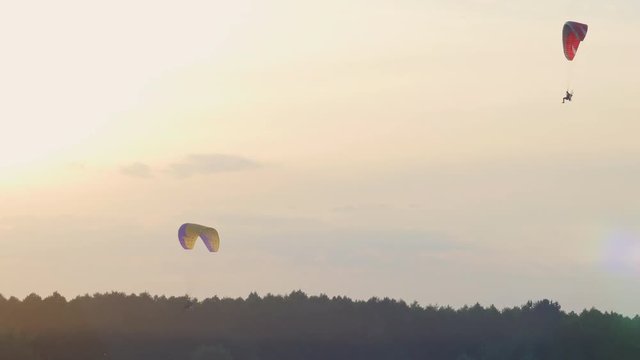 Two paratroopers on the Power ParaChute are flying over the fields