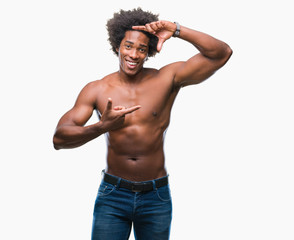 Fototapeta premium Afro american shirtless man showing nude body over isolated background smiling making frame with hands and fingers with happy face. Creativity and photography concept.