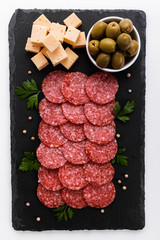 delicious sliced salami on a stone plate white background