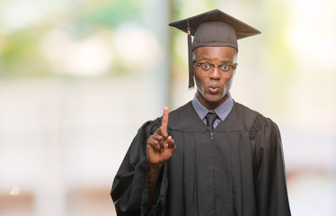 Young graduated african american man over isolated background showing and pointing up with finger number one while smiling confident and happy.