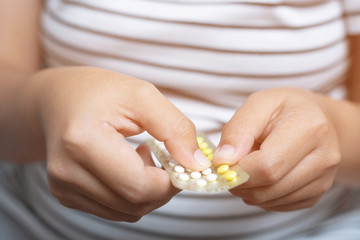 Woman hands opening birth control pills in hand. Eating Contraceptive Pill.	
