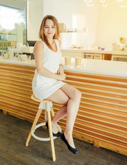 Beauty portrait of young women enjoy coffee in coffee shop on wooden table. Fascinating fashion model posing