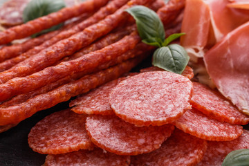 Cold smoked meat plate on a rustic wooden background
