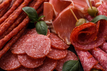 Cold smoked meat plate on a rustic wooden background