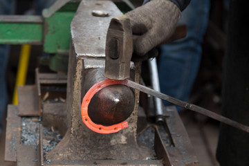 Making the horseshoe from heated red rod