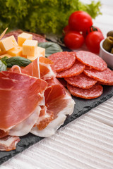 Cold smoked meat plate on a rustic wooden background